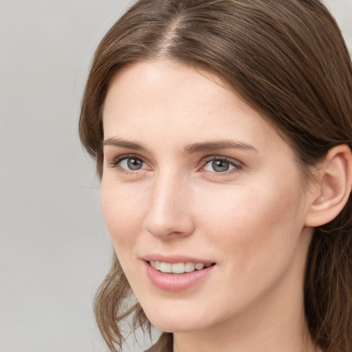 Joyful white young-adult female with medium  brown hair and grey eyes