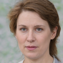 Joyful white adult female with medium  brown hair and green eyes