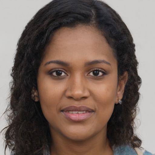 Joyful black young-adult female with long  brown hair and brown eyes