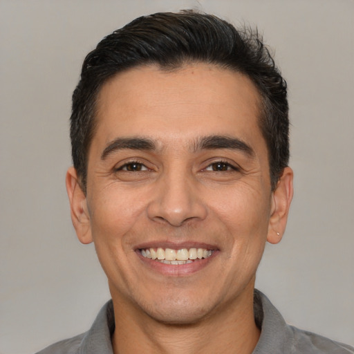 Joyful white young-adult male with short  black hair and brown eyes