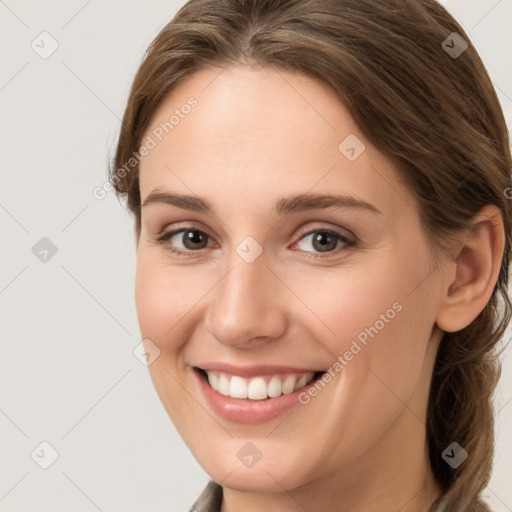 Joyful white young-adult female with long  brown hair and grey eyes