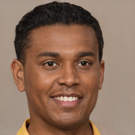 Joyful black young-adult male with short  brown hair and brown eyes
