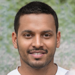 Joyful latino young-adult male with short  brown hair and brown eyes