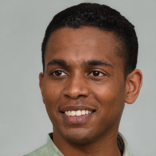 Joyful black young-adult male with short  black hair and brown eyes