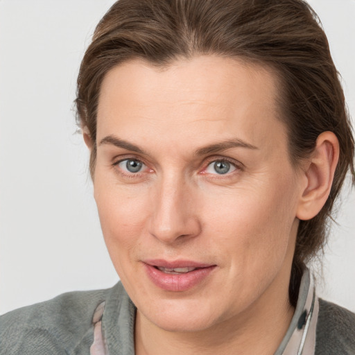 Joyful white adult female with medium  brown hair and grey eyes