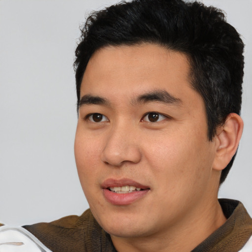 Joyful asian young-adult male with short  brown hair and brown eyes