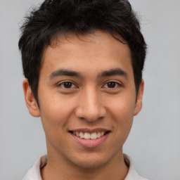 Joyful latino young-adult male with short  brown hair and brown eyes