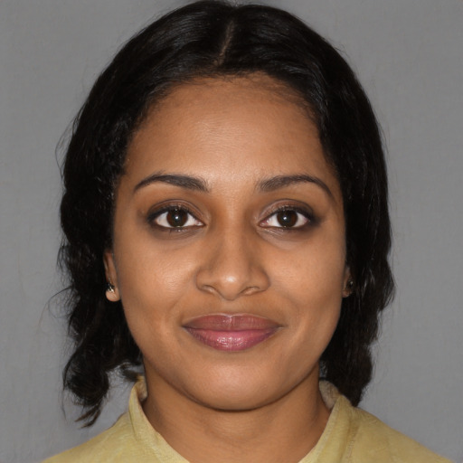 Joyful black young-adult female with medium  black hair and brown eyes
