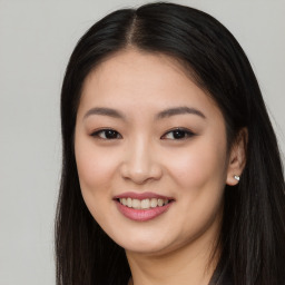 Joyful asian young-adult female with long  brown hair and brown eyes