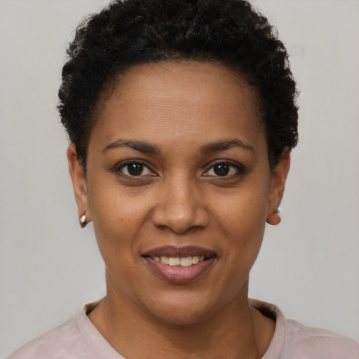 Joyful black young-adult female with short  black hair and brown eyes