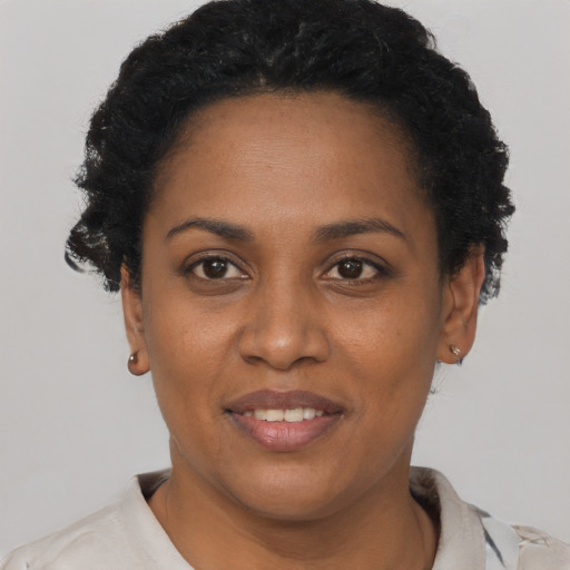 Joyful black adult female with short  black hair and brown eyes