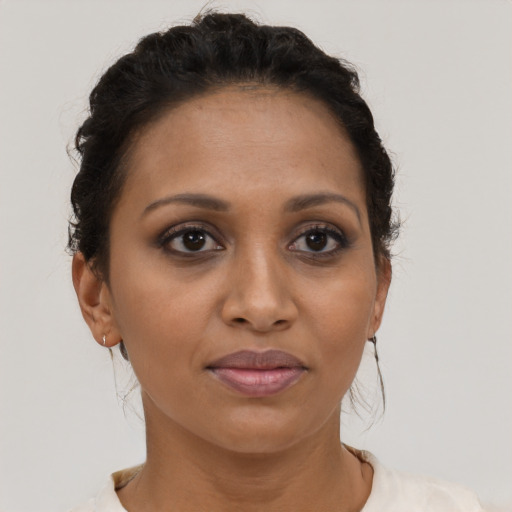 Joyful black young-adult female with short  brown hair and brown eyes