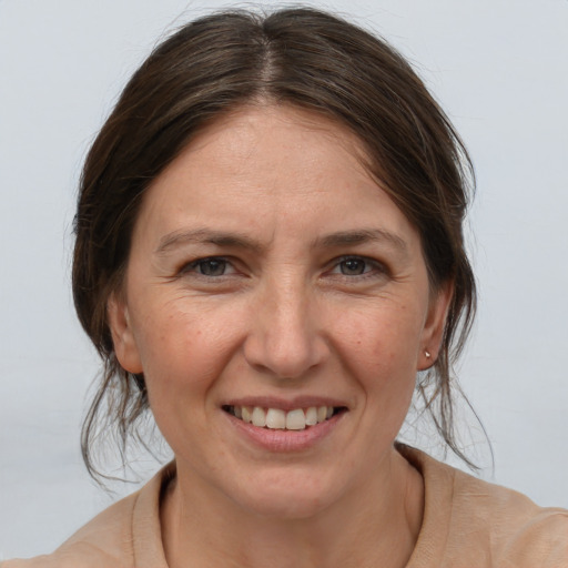 Joyful white adult female with medium  brown hair and brown eyes