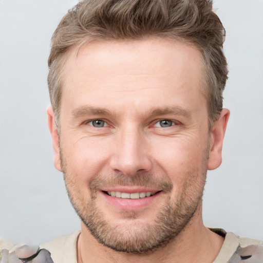 Joyful white adult male with short  brown hair and grey eyes