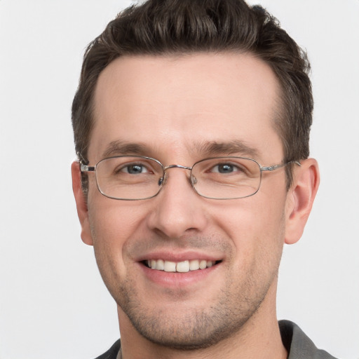 Joyful white young-adult male with short  brown hair and grey eyes