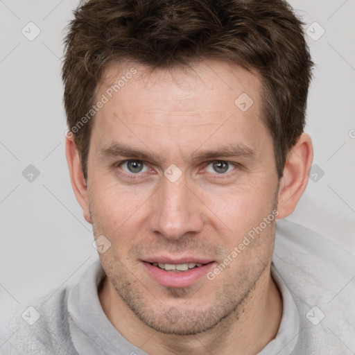 Joyful white young-adult male with short  brown hair and grey eyes