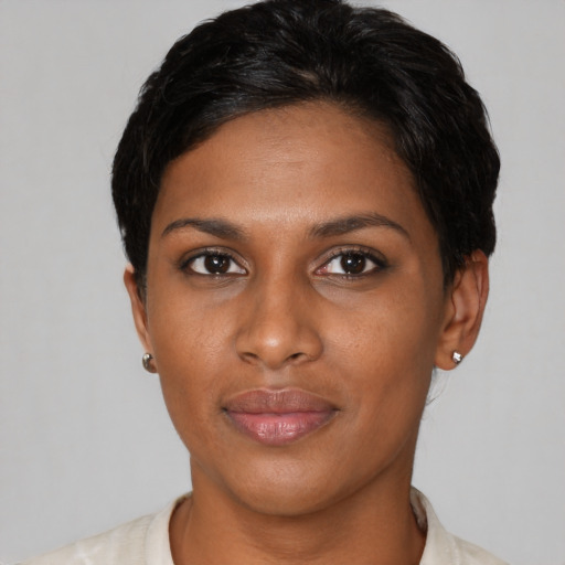 Joyful latino young-adult female with short  black hair and brown eyes