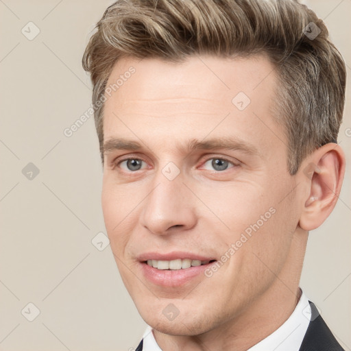 Joyful white young-adult male with short  brown hair and grey eyes