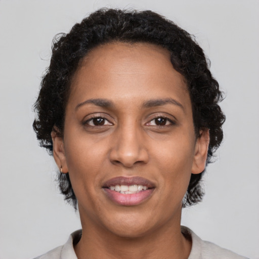 Joyful black adult female with short  brown hair and brown eyes