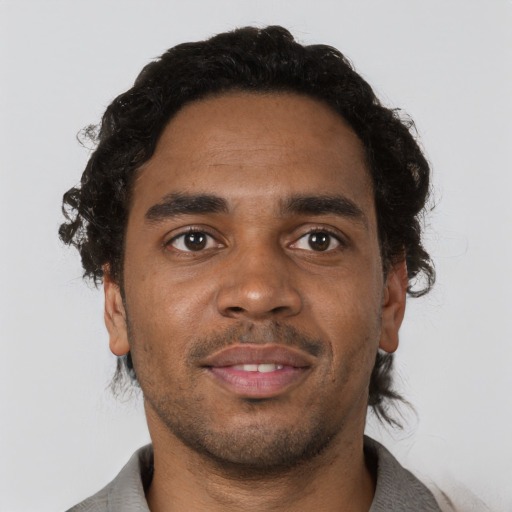Joyful black young-adult male with short  brown hair and brown eyes