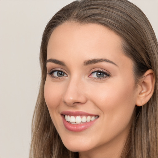 Joyful white young-adult female with long  brown hair and grey eyes