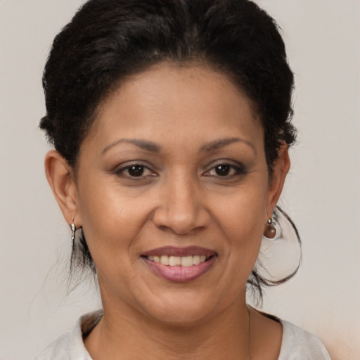 Joyful latino adult female with medium  brown hair and brown eyes