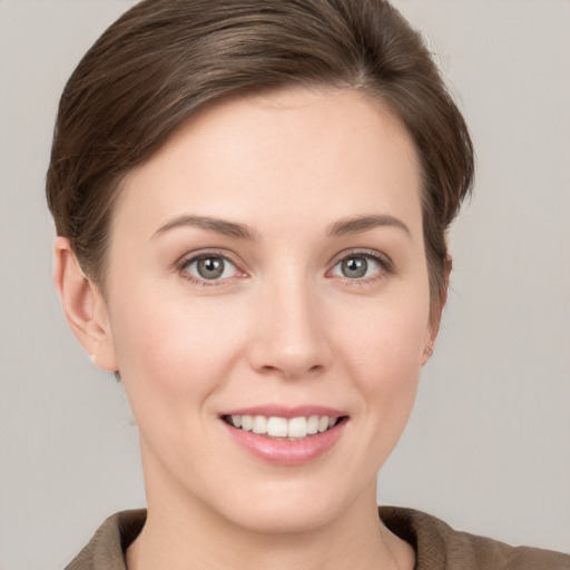 Joyful white young-adult female with short  brown hair and grey eyes