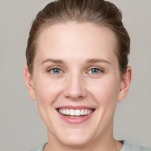 Joyful white young-adult female with short  brown hair and grey eyes