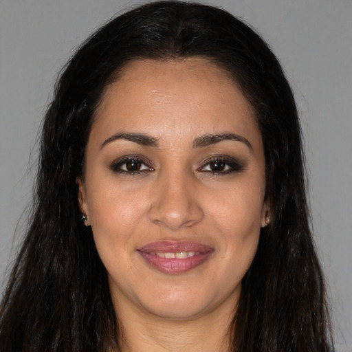 Joyful latino young-adult female with long  brown hair and brown eyes