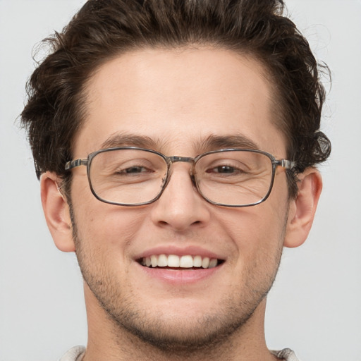 Joyful white adult male with short  brown hair and grey eyes