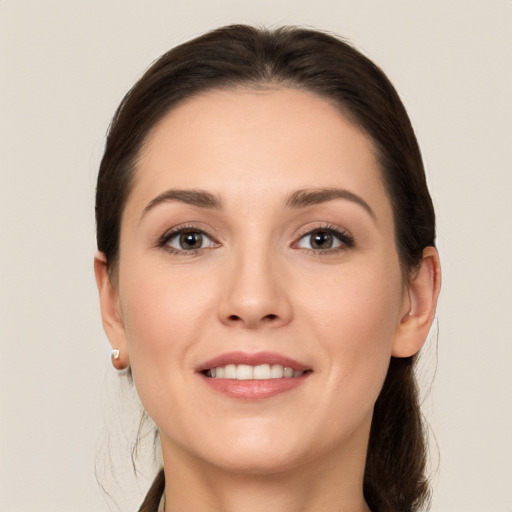 Joyful white young-adult female with long  brown hair and grey eyes