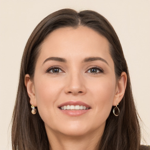 Joyful white young-adult female with long  brown hair and brown eyes