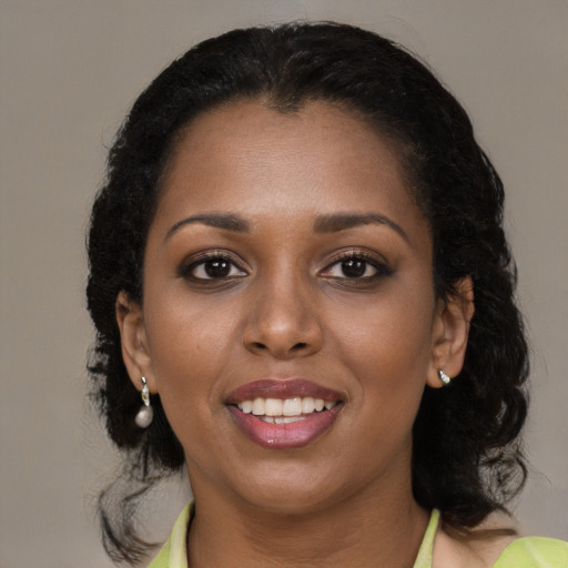Joyful black young-adult female with medium  black hair and brown eyes