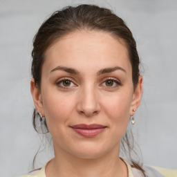 Joyful white young-adult female with medium  brown hair and grey eyes