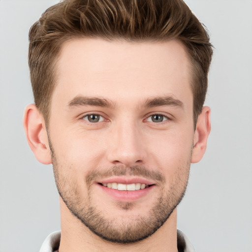 Joyful white young-adult male with short  brown hair and grey eyes