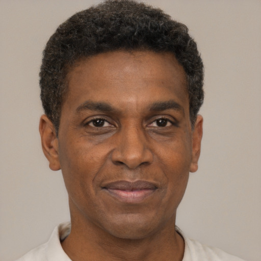 Joyful black adult male with short  black hair and brown eyes