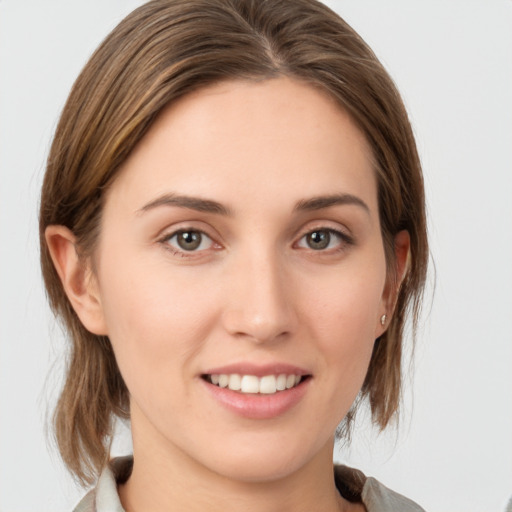 Joyful white young-adult female with medium  brown hair and grey eyes