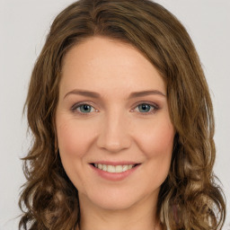 Joyful white young-adult female with long  brown hair and green eyes