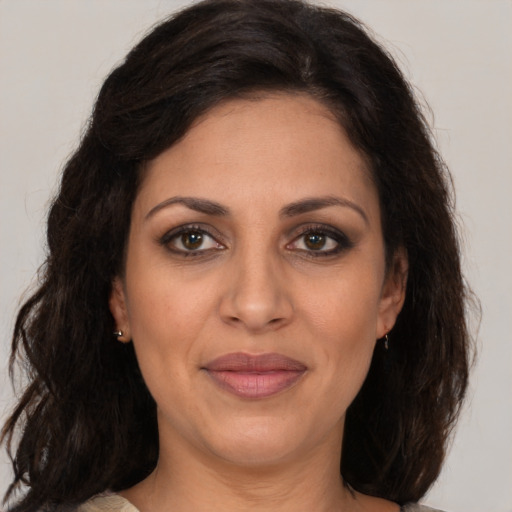 Joyful latino adult female with medium  brown hair and brown eyes