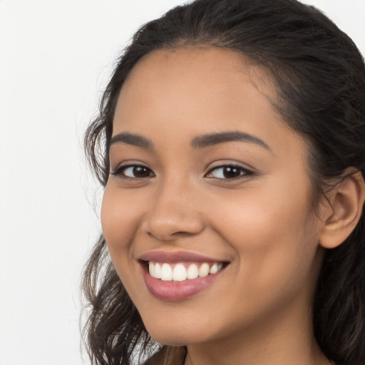 Joyful latino young-adult female with long  brown hair and brown eyes