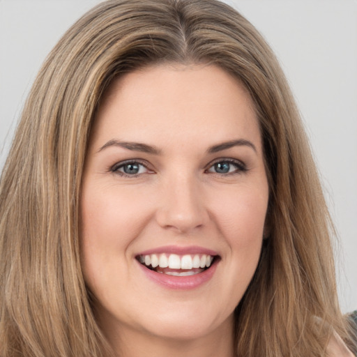 Joyful white young-adult female with long  brown hair and green eyes