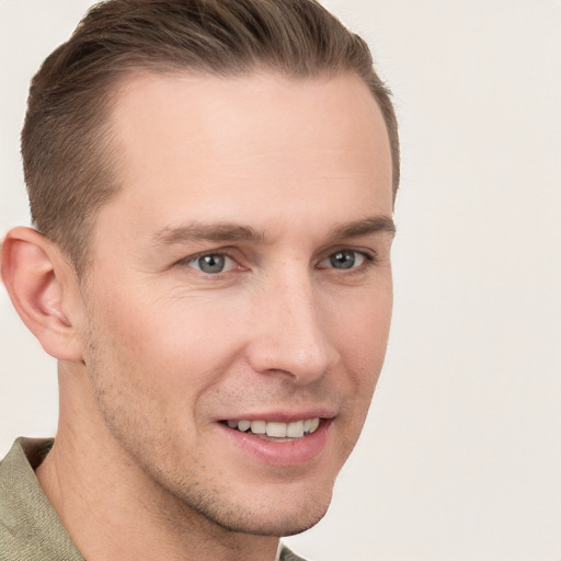 Joyful white young-adult male with short  brown hair and grey eyes