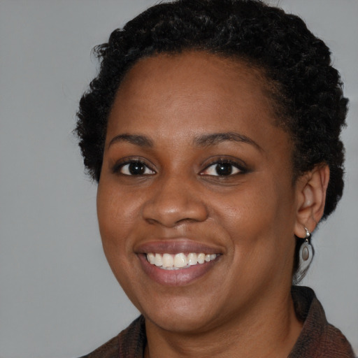 Joyful black young-adult female with medium  brown hair and brown eyes