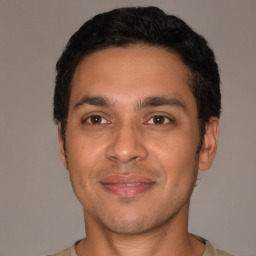 Joyful latino young-adult male with short  brown hair and brown eyes