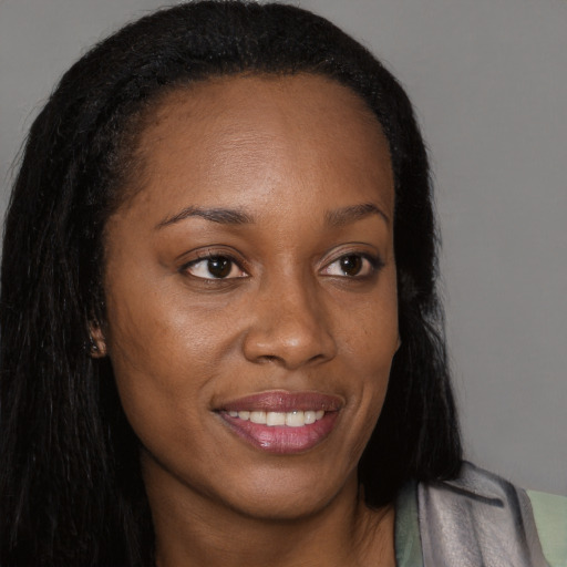 Joyful black young-adult female with long  brown hair and brown eyes
