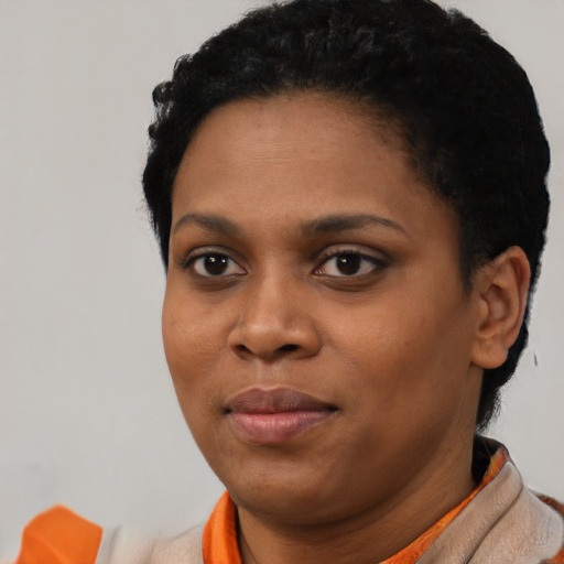 Joyful black young-adult female with short  black hair and brown eyes