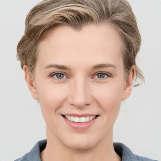 Joyful white young-adult female with short  brown hair and grey eyes