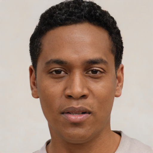 Joyful black young-adult male with short  black hair and brown eyes