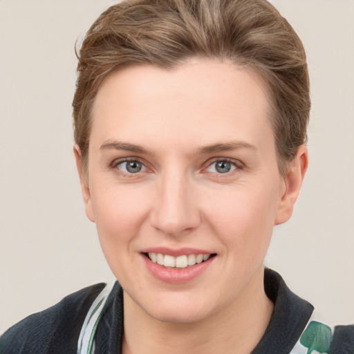 Joyful white young-adult female with short  brown hair and grey eyes