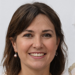 Joyful white adult female with long  brown hair and grey eyes